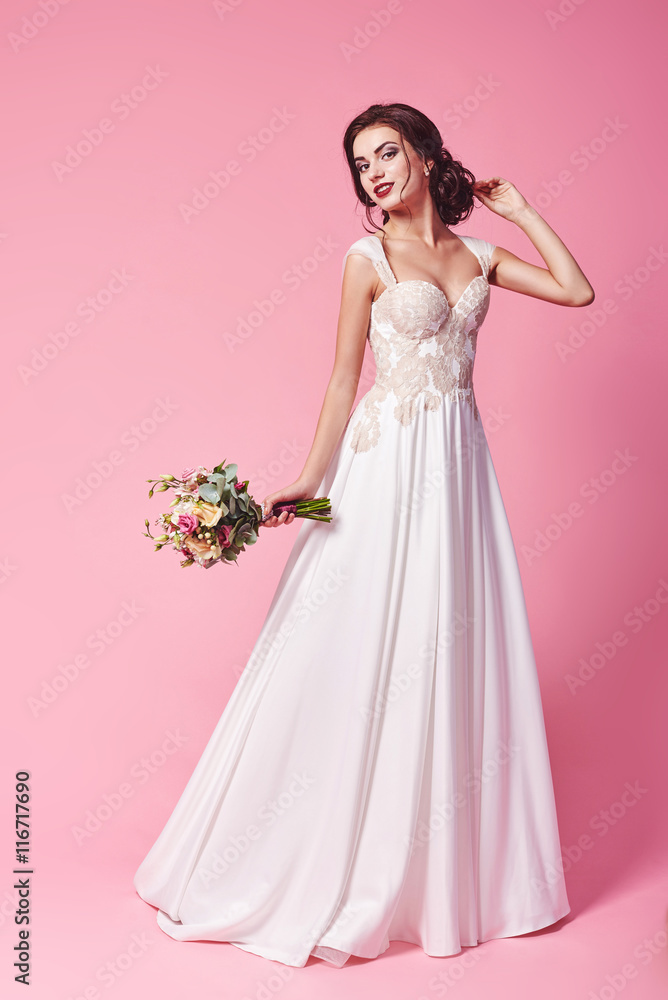 Bride.Young fashion model with perfect skin and make up, beige background, curly hair, flowers in hair Bride.Young fashion model with perfect skin and make up, beige background, curly hair, flowers in hair