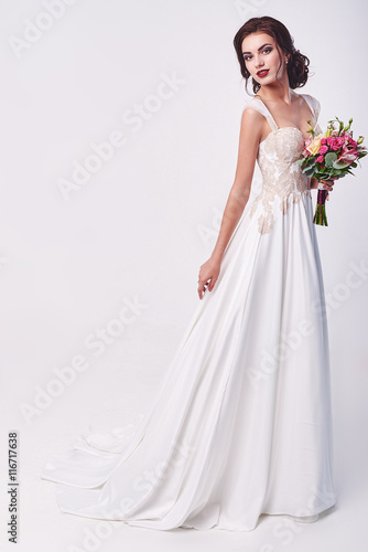 Woman in wedding dress with flowers' bouquet.