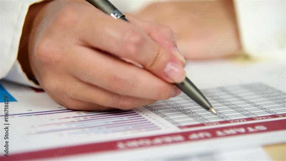 Woman Hand Checks Start Up Report. Close Up Woman Hand Checks Start Up Report. Close Up