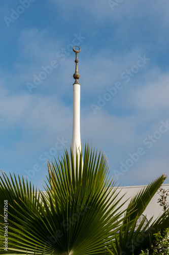 Islamic center spire with crescent and blue sky