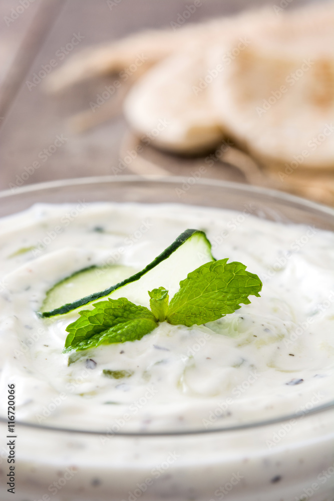 Tzatziki sauce in bowl on rustic wooden table
Tzatziki sauce in bowl on rustic wooden table