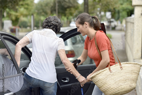 Принти на полотні Young carer helping senior woman getting in car