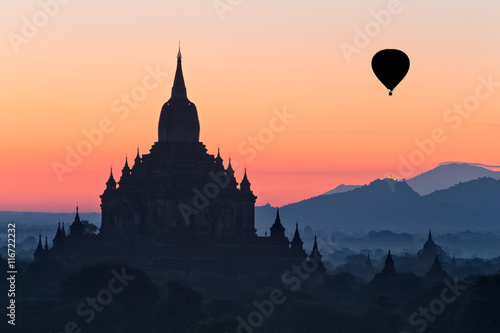 Silhouette of temple and hot air balloon at dawn, Myanmar photo