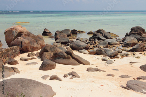 Volcanic boulders and stones on sandy beach. Mahe, Seychelles