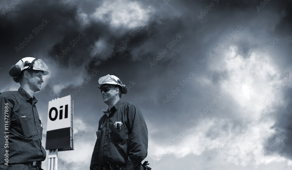 fuel and oil, refinery workers with large information-sign outside refinery fuel and oil, refinery workers with large information-sign outside refinery