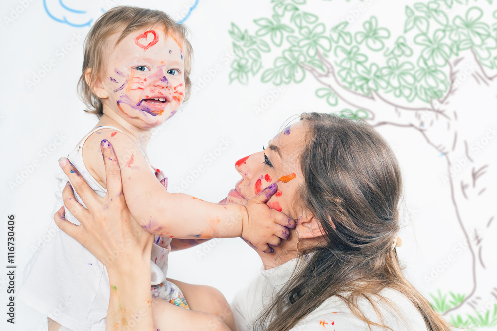 Mom and baby draws with colored inks paint