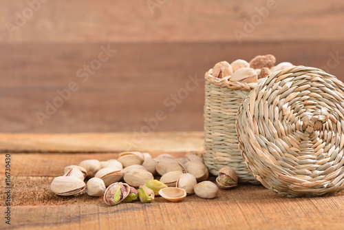 Roasted and salted pistachios in a basket on a rustic table