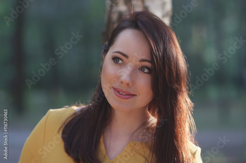 Portrait of a beautiful woman on a forest background. People