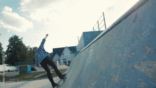 skateboarder in action on a ramp, doing stall trick, rock to fakie on skateboard photo