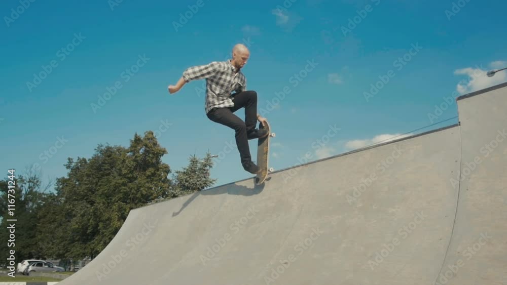 skateboarder in action on a ramp, doing stall trick, rock to fakie on skateboard skateboarder in action on a ramp, doing stall trick, rock to fakie on skateboard