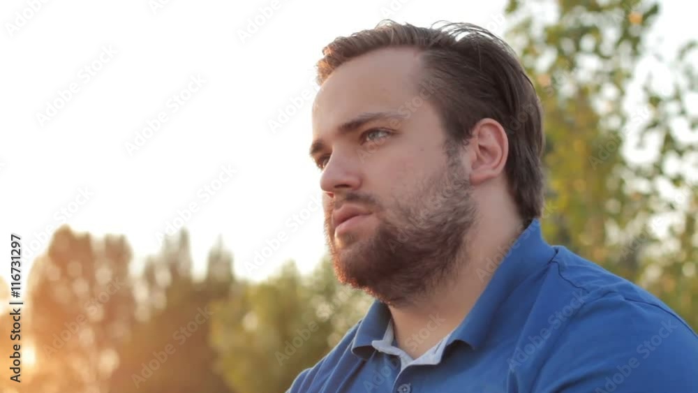 Portrait of a lonely man smoking a cigarette in sunlight Portrait of a lonely man smoking a cigarette in sunlight