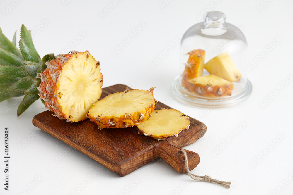 Ripe pineapple pieces on a white table Ripe pineapple pieces on a white table