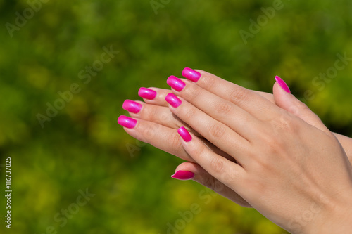 Woman hands with manicured pink nails closeup. Skin and nail car