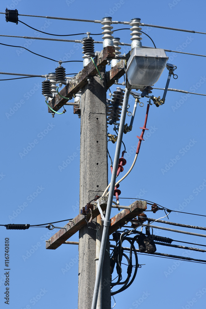 Concrete pole with wires and isolators and attached street light. Concrete pole with wires and isolators and attached street light.