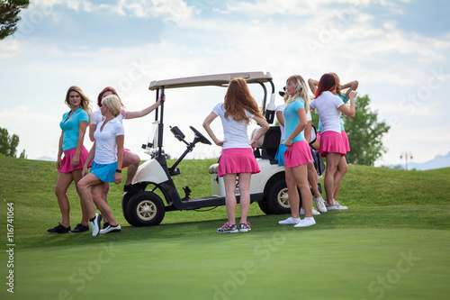 Group of young golf caddies hanging out on golf cart