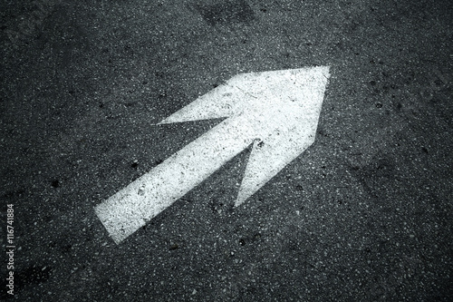 Straight arrow sign on asphalt floor. Black and white color tone used.