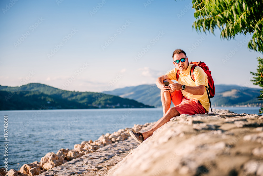 Man sitting by the sea and using smart phone