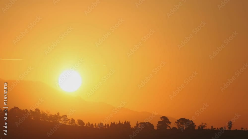 Time lapse of the sun rising behind low mountains Time lapse of the sun rising behind low mountains