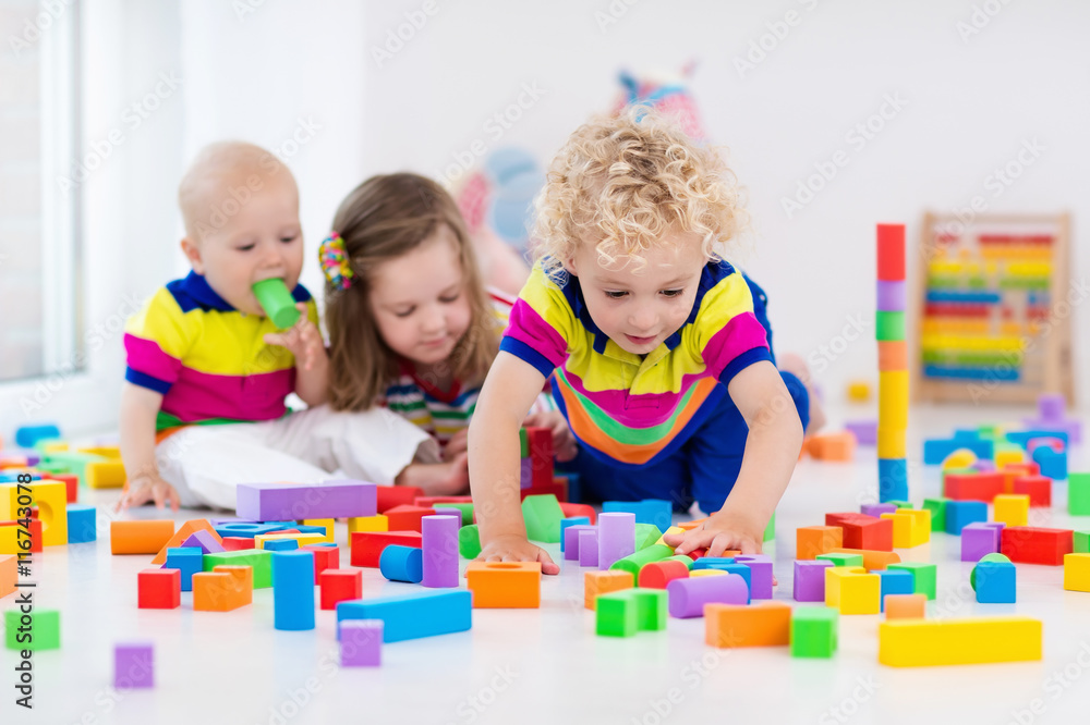 Fototapeta premium Kids playing with colorful toy blocks