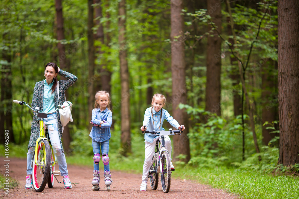 Fototapeta premium Happy family biking outdoors at the park