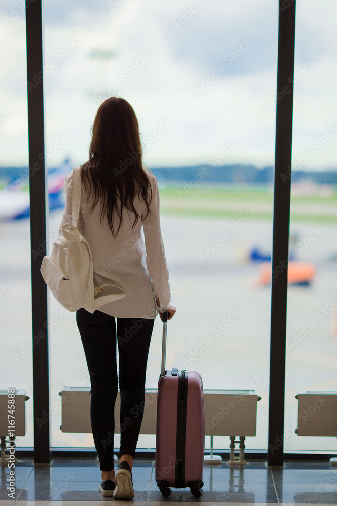 Silhouette of airline passenger in an airport lounge waiting for flight aircraft Silhouette of airline passenger in an airport lounge waiting for flight aircraft