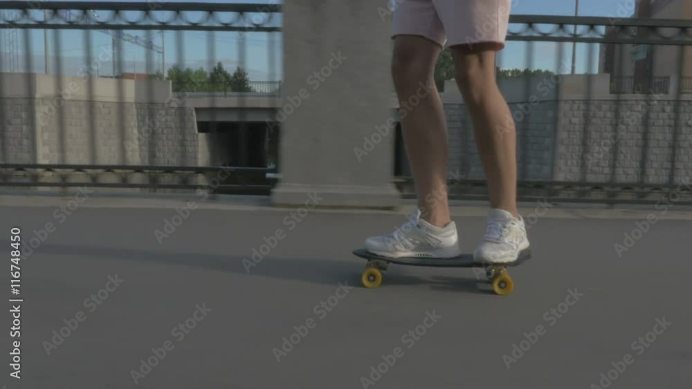 Legs of skateboarder to ride a skateboard on the road in the city Legs of skateboarder to ride a skateboard on the road in the city