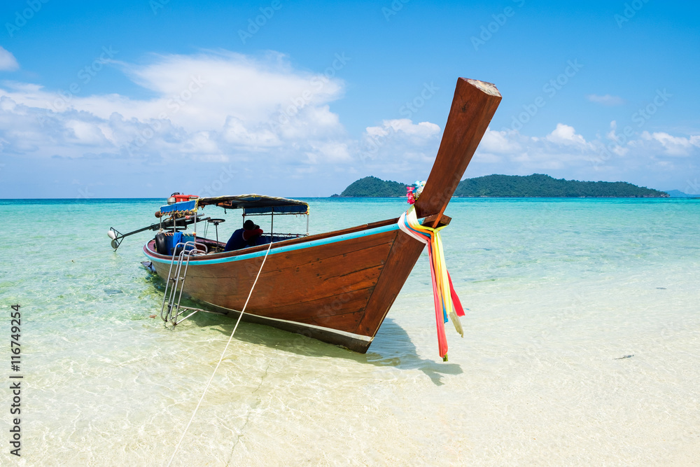 Long tail wooden boat anchor with csytal sea white sand at lipe island,andaman,thailand Long tail wooden boat anchor with csytal sea white sand at lipe island,andaman,thailand
