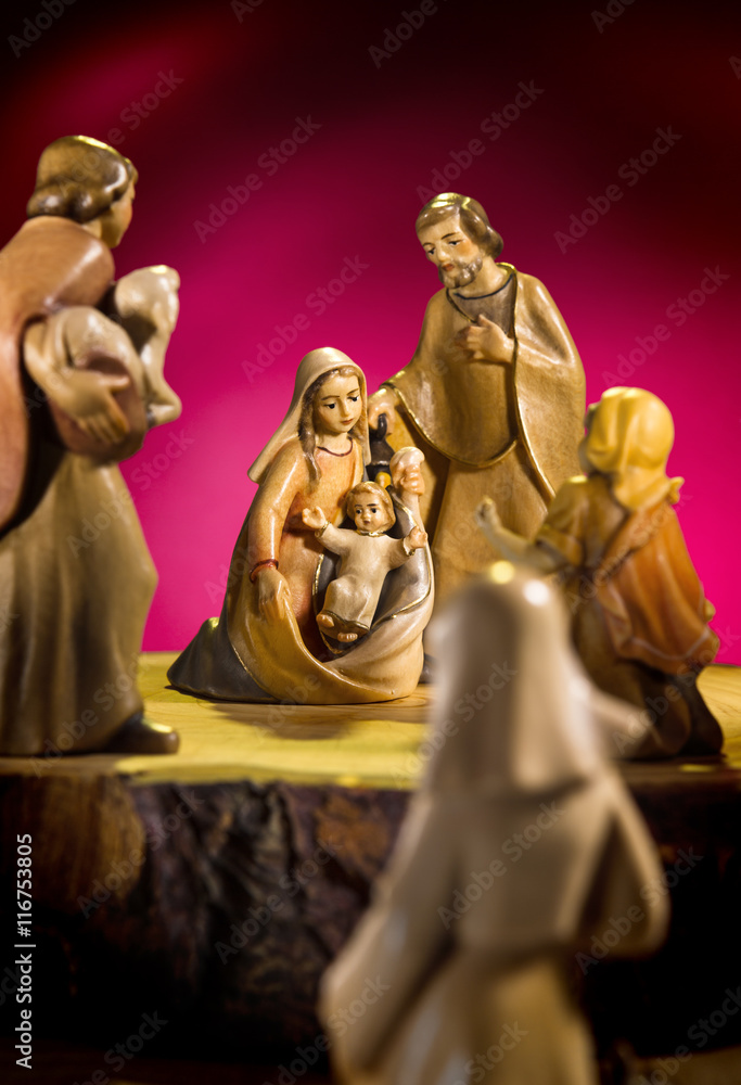 Krippenfiguren auf Holz mit rotem Hintergrund Krippenfiguren auf Holz mit rotem Hintergrund
