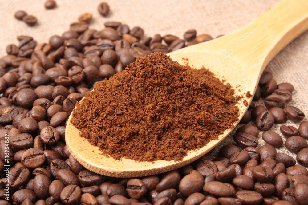 Ground coffee in a wooden spoon close-up on a background of coff Ground coffee in a wooden spoon close-up on a background of coff