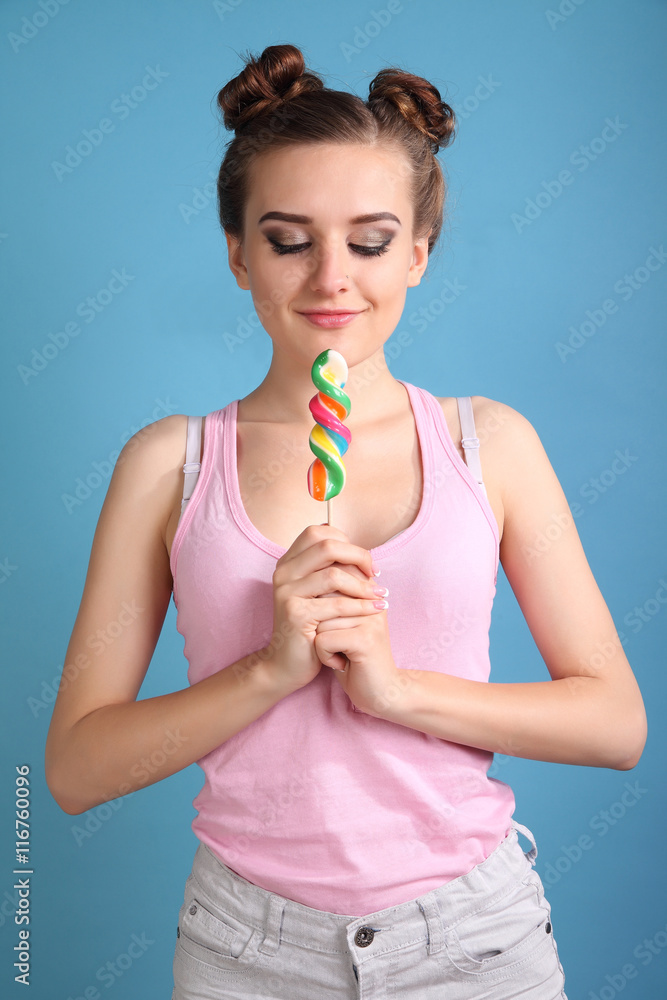 Young happy girl with colored candy