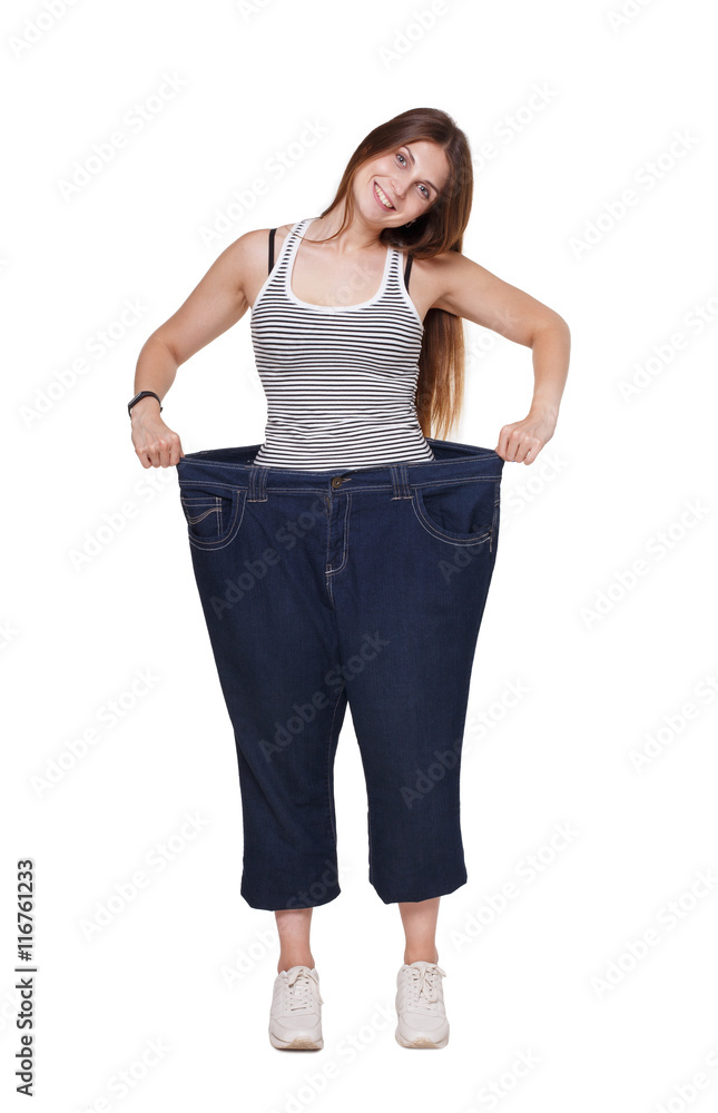 Obraz premium Young woman happy of weight loss diet results, isolated