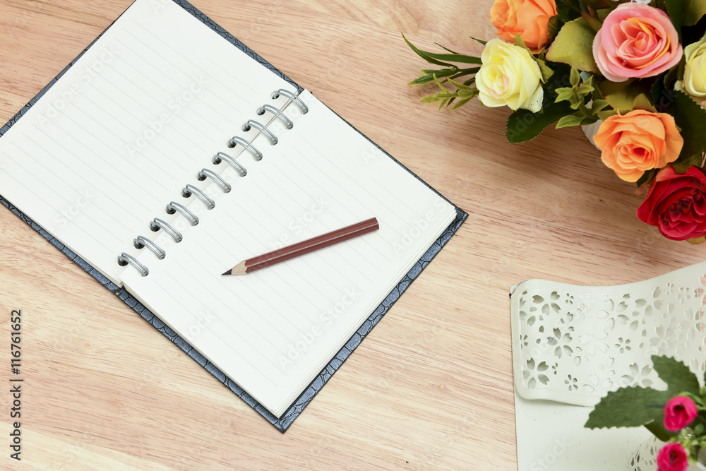 Pencil and open notebook on wood background in selective focus. Pencil and open notebook on wood background in selective focus.