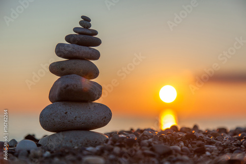 Canvas The rock cairn on the beach, on a beautiful bright sunset