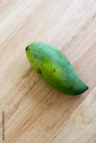 Whole Green Mango on a wooden table.In selective focus.