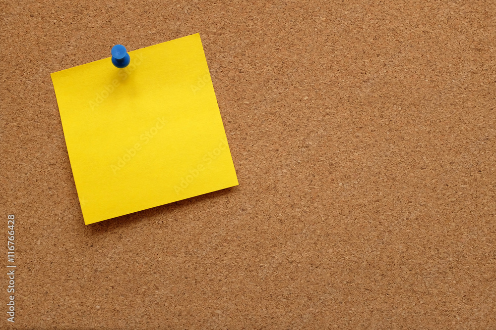 Yellow note paper pinned to a cork board Yellow note paper pinned to a cork board