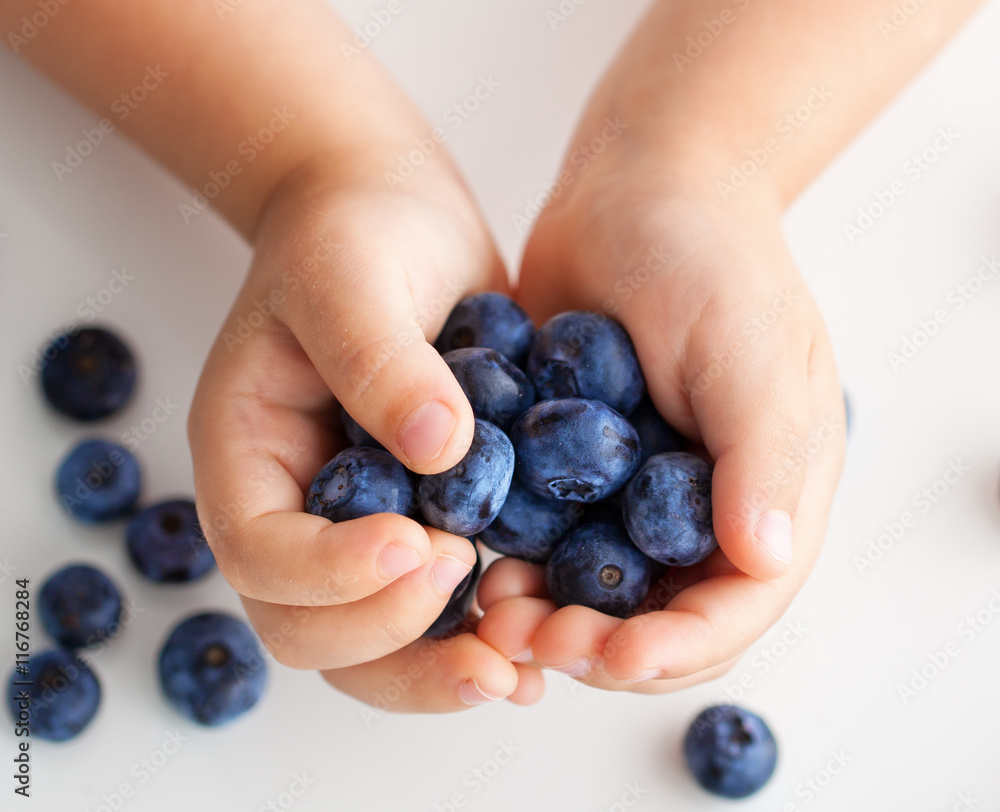 a handful of berries in children's hands