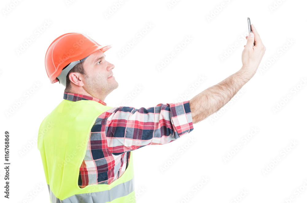Attractive constructor taking a selfie with smartphone Attractive constructor taking a selfie with smartphone