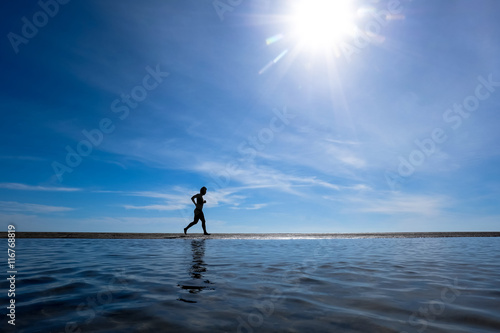 silhouette of man running on the beach