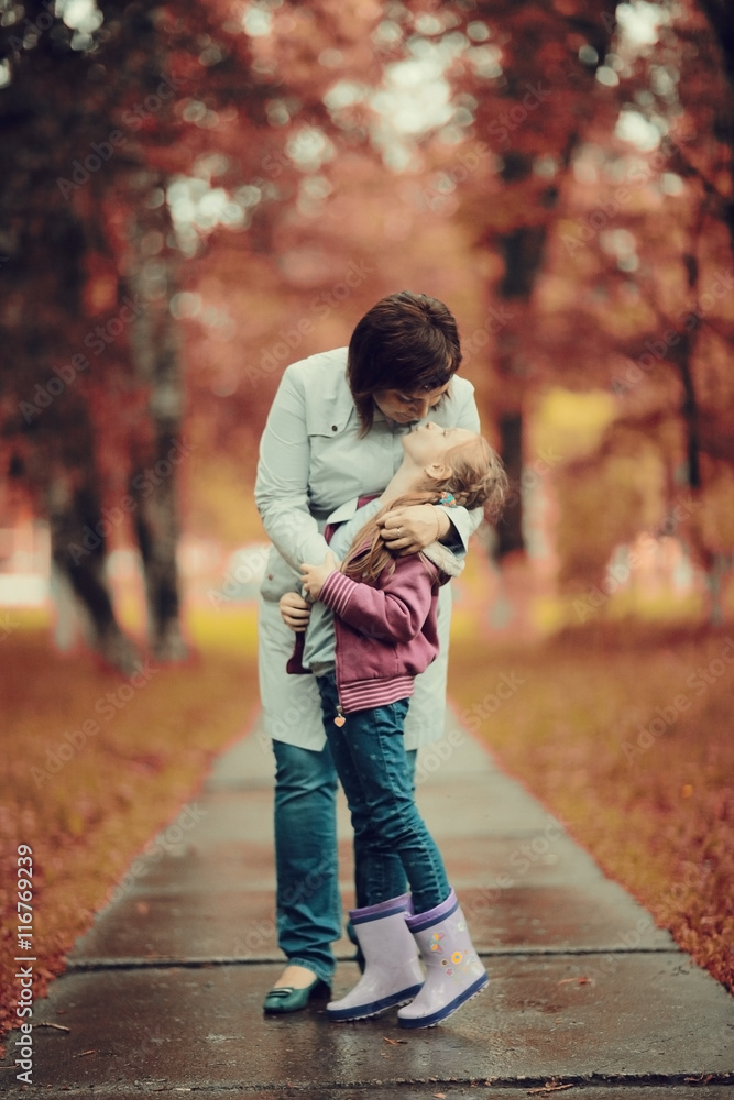 Fototapeta premium mother hugging her daughter, Autumn Park
