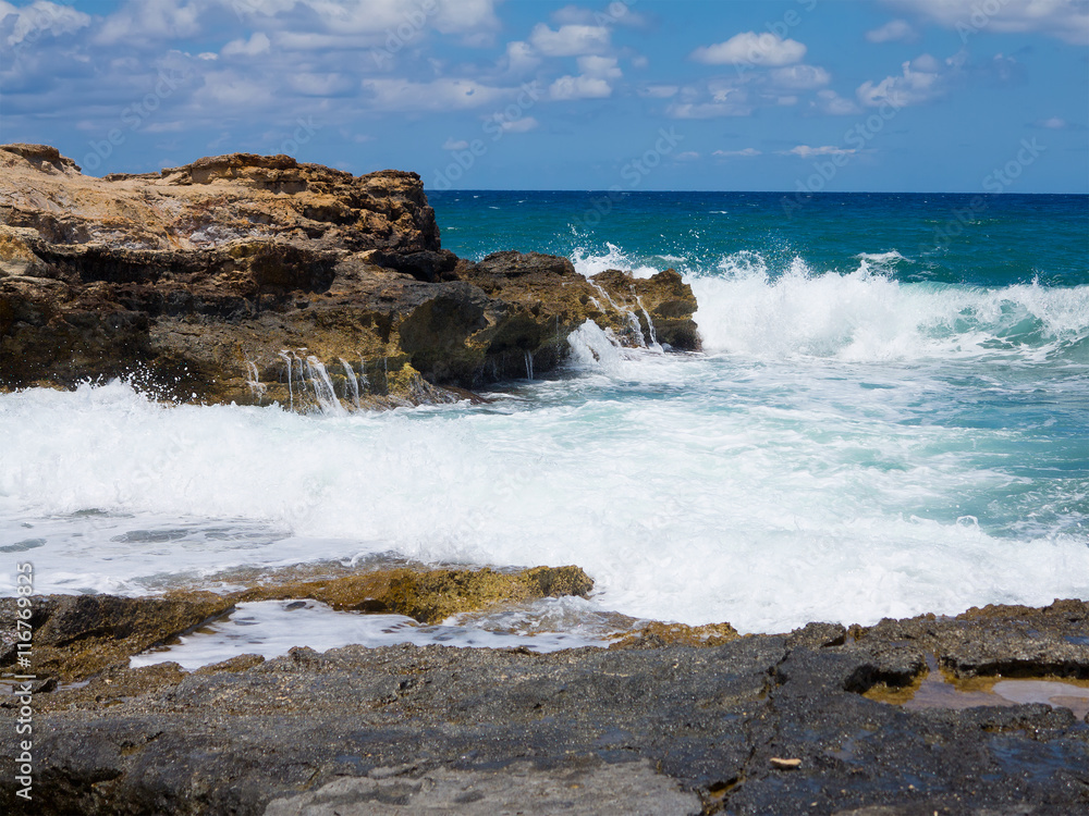 Big waves on rock coast blue sea and sky on Crete