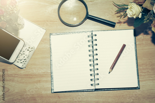 Open Blank notebook and pencil with magnifying glasses and