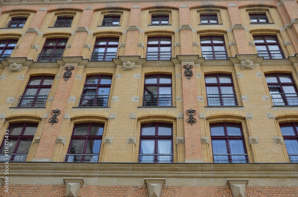 Facade of red brick building with many windows Facade of red brick building with many windows