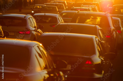 Cars are in traffic jam during a beautiful golden sunset.