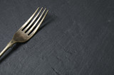 Antique silver fork on a rustic slate background