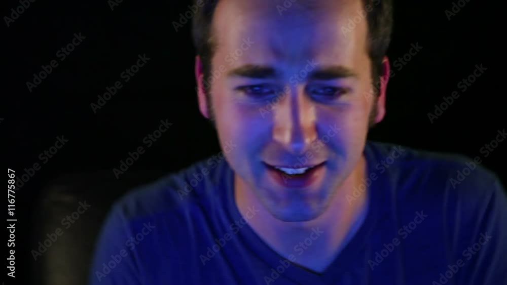 A man in his 20's intensely playing video games. A man in his 20's intensely playing video games.