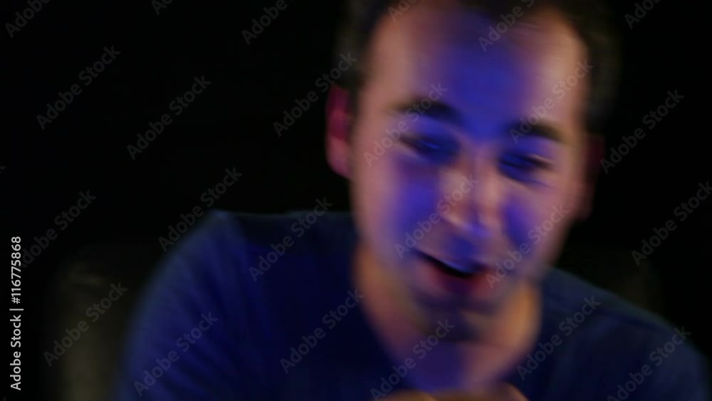 A man in his 20's intensely playing video games. A man in his 20's intensely playing video games.