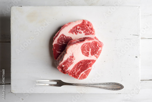 Raw marbled beef on a cutting board and fork