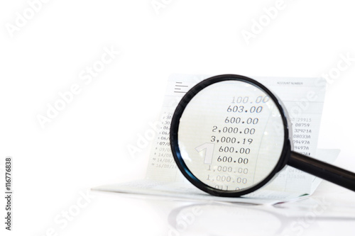 Bank account or saving deposit passbook with magnifying glass
