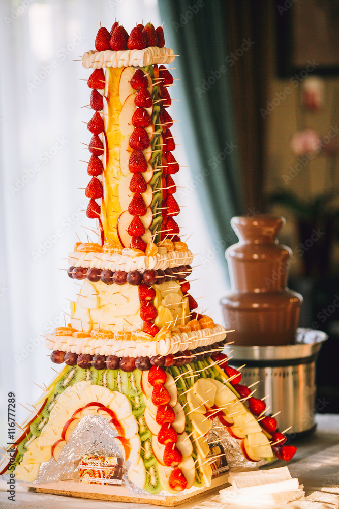 Friuit Eiffel tower for chocolate fountain fondue at candy bar. Stylish