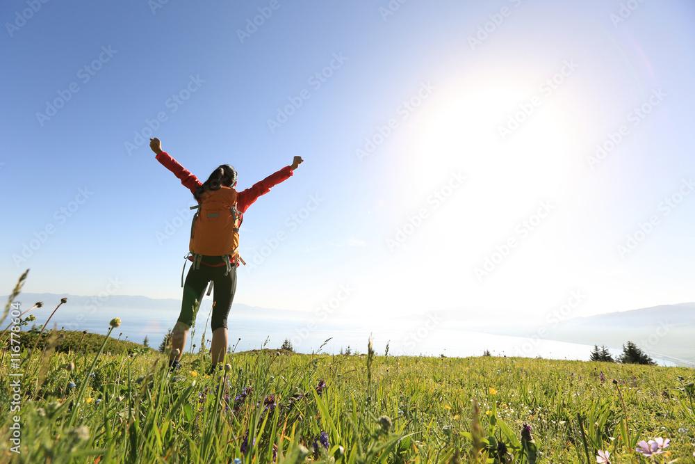 cheering successful woman backpacker open arms on mountain peak cheering successful woman backpacker open arms on mountain peak